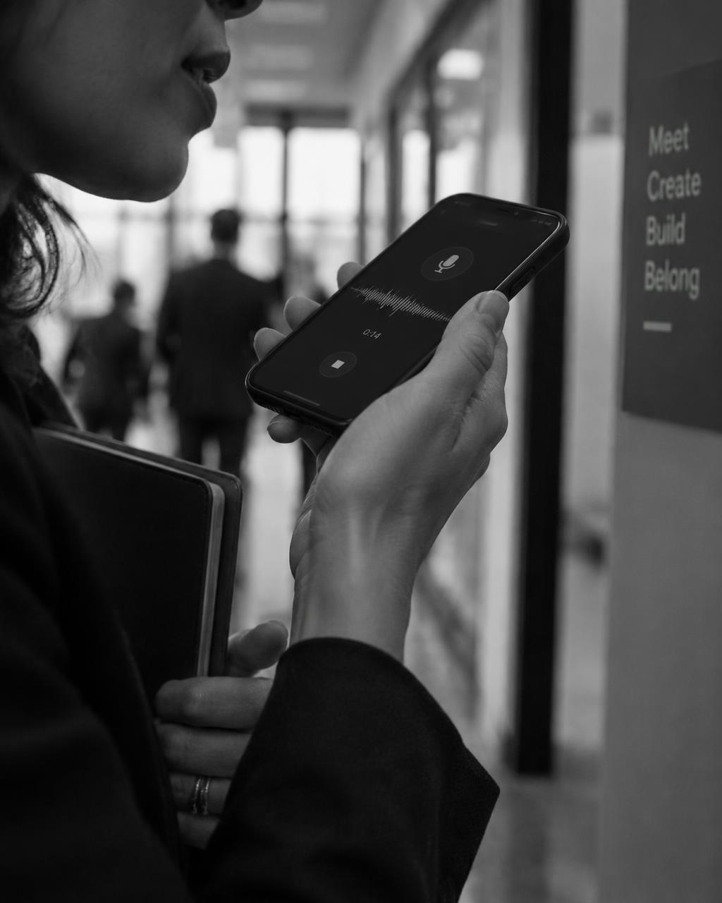 Hands holding a phone, recording a voice note just after a meeting